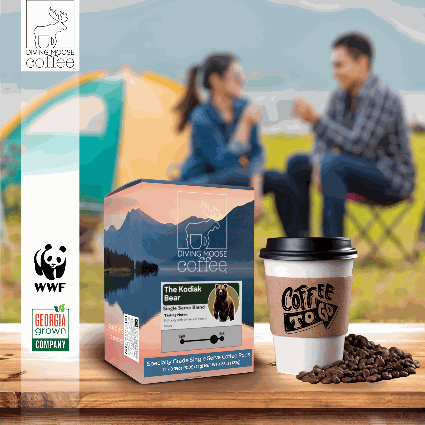 The Kodiak Bear dark roast coffee pods box with coffee cup and beans outdoorsCamping couple blurred background